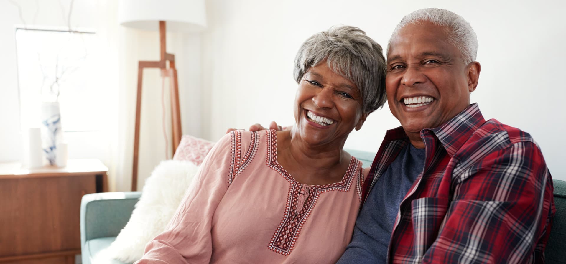 elderly couple hugging while smiling in front of the camera