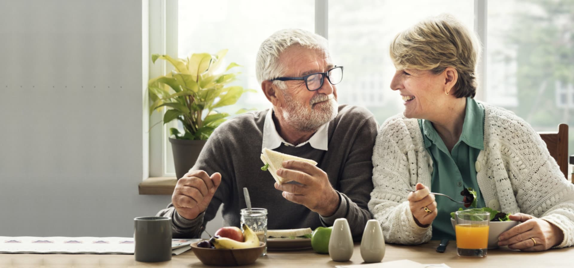 elderly couple talking to each other while eating