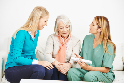 caregivers explaining medicine dosage to an elder woman at home
